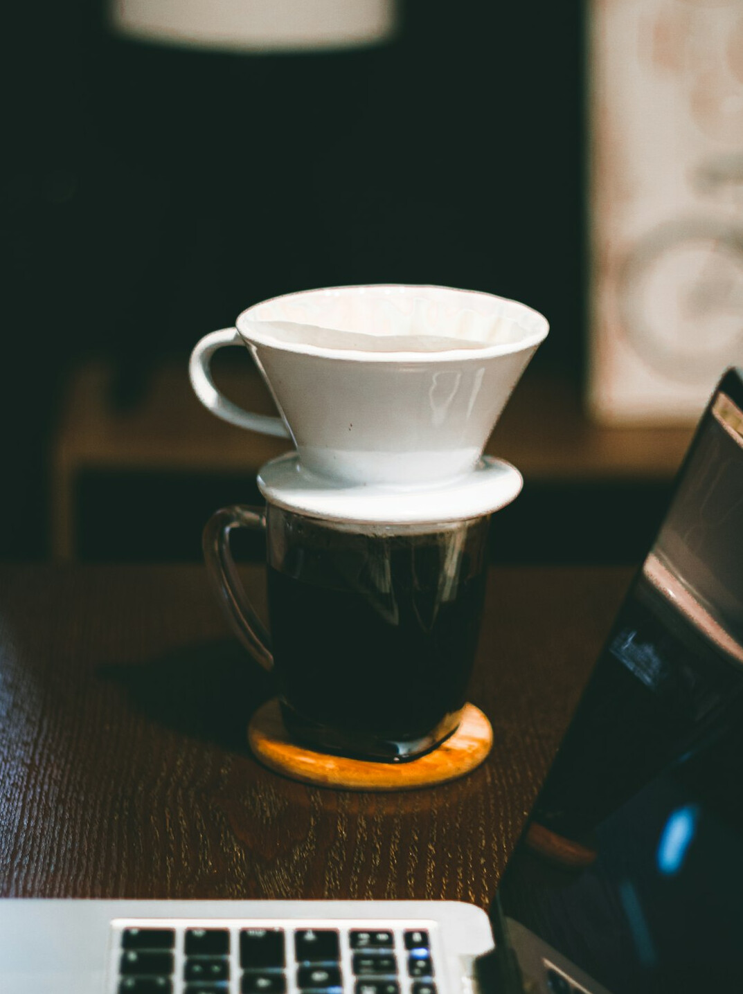 Laptop and coffee on a desk with notebook